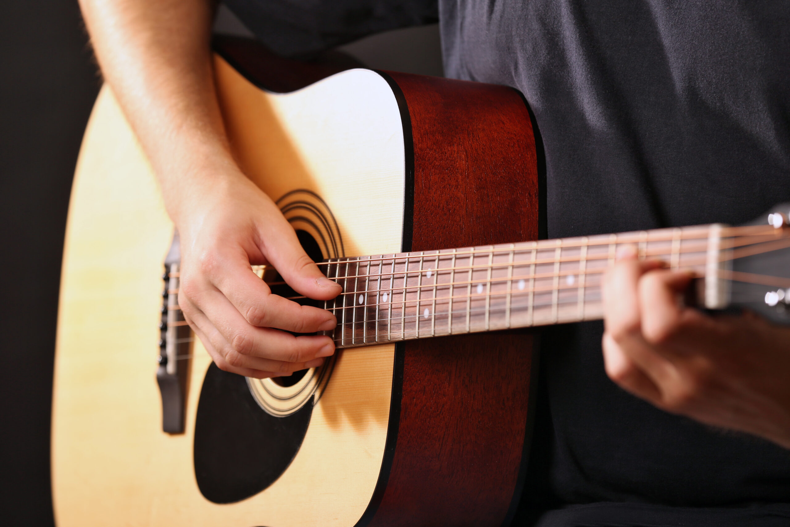 young man playing taylor guitar